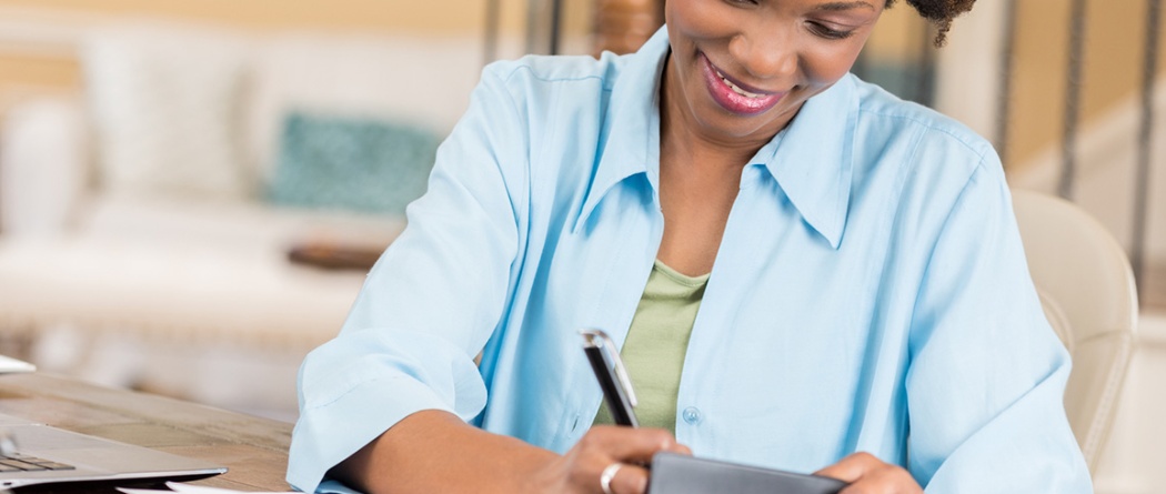 a woman writing in her checkbook